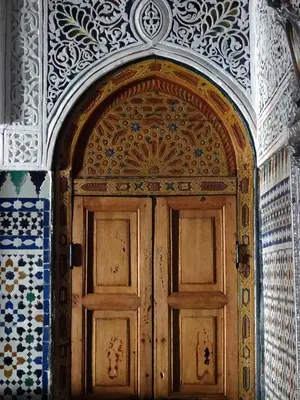 a wooden door in a room with tiles on the wall at Dar El Bali in Fès