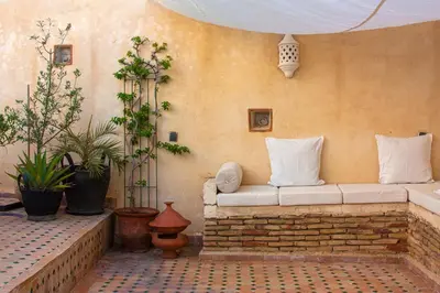a couch sitting against a wall with plants at Dar El Bali in Fès