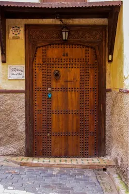 a large wooden door on the side of a building at Dar El Bali in Fès