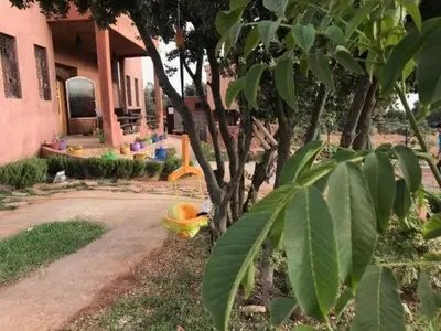 a house with a tree in front of a building at Maison d'hôtes Tinwitchi in Azilal