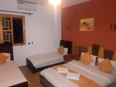 a hotel room with two beds and a window at Maison d'hôtes Tinwitchi in Azilal