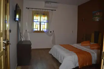 a bedroom with a bed and a window at Maison d'hôtes Tinwitchi in Azilal