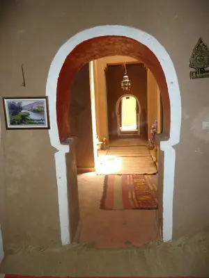 a hallway with an archway in a building at Riad Tagmadarte Ferme d'Hôte in Zagora