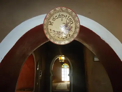 a clock hanging over a hallway in a building at Riad Tagmadarte Ferme d'Hôte in Zagora