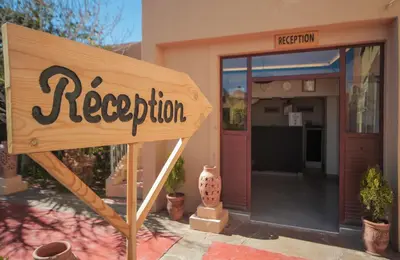 a sign in front of a restaurant with a reception at Hotel Kasbah Ennakhile - Authentic Stay in Nkob in Nkob