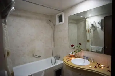 a bathroom with a sink and a tub and a mirror at Hôtel Rif in Meknès