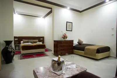 a hotel room with two beds and a table at Hôtel Rif in Meknès