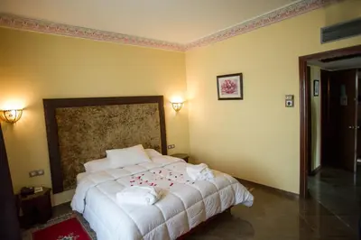 a bedroom with a white bed with flowers on it at Hôtel Rif in Meknès