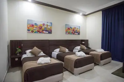 a room with three beds with towels on them at Hôtel Rif in Meknès