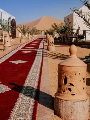 a red carpeted walkway in the middle of a desert at Asama Luxury Camp in Merzouga