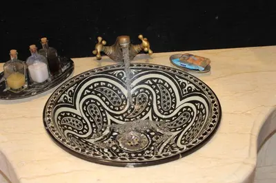 a plate on a table with a water fountain at Asama Luxury Camp in Merzouga
