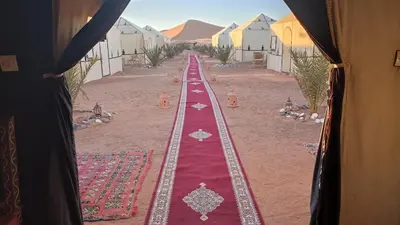 a long red carpet in the middle of a desert at Asama Luxury Camp in Merzouga