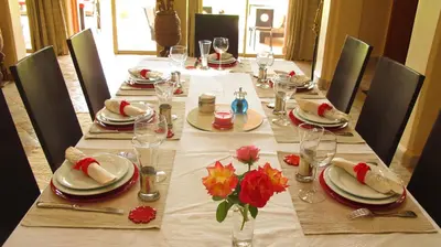 a long table with plates and glasses and flowers on it at Dar Kamango in Marrakech
