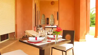 a dining table with plates and wine glasses on it at Dar Kamango in Marrakech