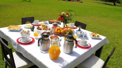 a white table with breakfast foods and orange juice at Dar Kamango in Marrakech