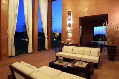 a living room with white furniture and large windows at Dar Kamango in Marrakech