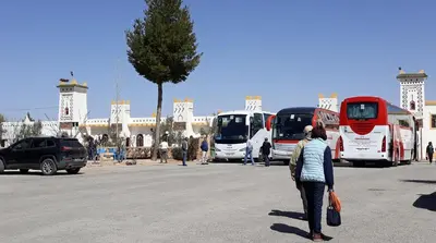 a group of buses parked in a parking lot at Ksar Timnay Hotel in Aguelmous
