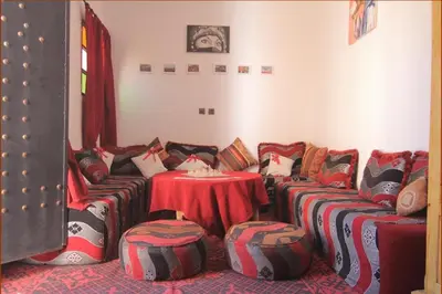 a room with a couch and a table with pillows at Karim Sahara in Zagora