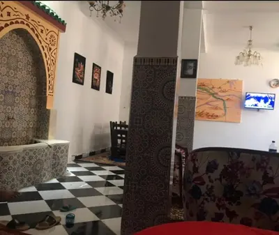 a room with a checkered floor and a room with a chandelier at Karim Sahara in Zagora