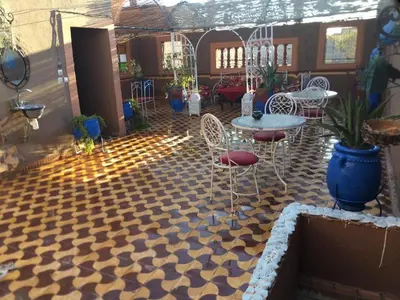 a patio with a table and chairs on a checkered floor at Karim Sahara in Zagora