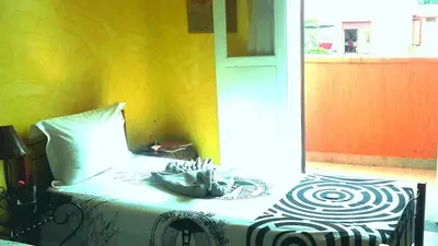 a bed in a room with a yellow wall at Riad Dar Zidane in Meknès