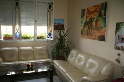 a living room with a leather couch and a table at Riad Dar Zidane in Meknès