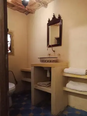 a bathroom with a sink and a mirror at Kasbah du Peintre in Aït Ben Haddou