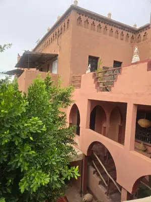 a brick building with a staircase in front of it at Kasbah du Peintre in Aït Ben Haddou