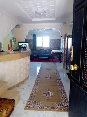 a living room with a lobby with a bar and a couch at Hotel Ain Leuh in Aïn Leuh