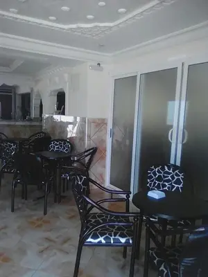 a dining room with black chairs and tables in a room at Hotel Ain Leuh in Aïn Leuh