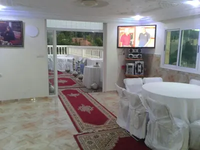 a room with a white table and chairs and a room with a table at Hotel Ain Leuh in Aïn Leuh