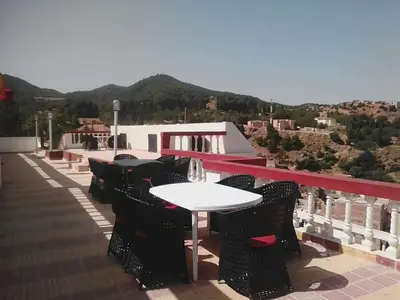 a table and chairs on the roof of a building at Hotel Ain Leuh in Aïn Leuh