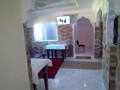 a room with two tables and a chair and a window at Hotel Ain Leuh in Aïn Leuh