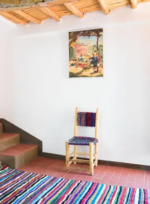 a chair sitting in a room with a rug at Monkey Fingers House by Fatima mellal in Tinerhir