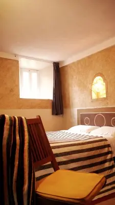 a bedroom with two beds and a chair and a window at Monkey Fingers House by Fatima mellal in Tinerhir