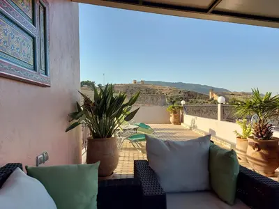 a balcony with a couch and some potted plants at Dar Hayati in Fès