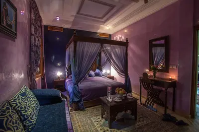 a bedroom with a canopy bed in a purple room at Riad Raouia HAMMAM & SPA in Fès