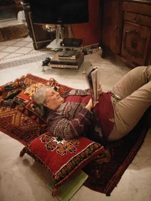 a woman laying on the floor reading a book at Riad Raouia HAMMAM & SPA in Fès
