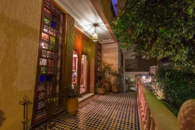 a hallway with a tiled floor and a door with plants at Riad Raouia HAMMAM & SPA in Fès