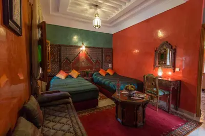 a living room with two beds and a table at Riad Raouia HAMMAM & SPA in Fès
