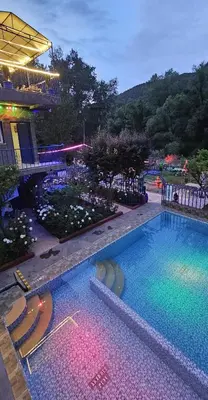 a large swimming pool with chairs in front of a building at Top Ourika in Aghbalou
