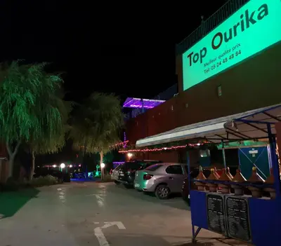 a parking lot in front of a building at night at Top Ourika in Aghbalou