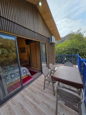 a deck with a bed and a table and chairs at Top Ourika in Aghbalou