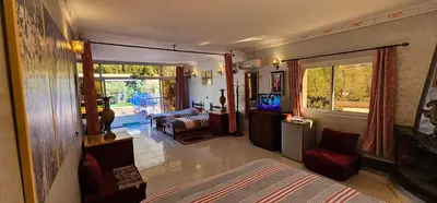 a room with a bed and a living room with a television at Top Ourika in Aghbalou