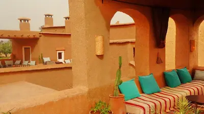 a couch with colorful pillows sitting on a patio at Les Jardins de Skoura in Skoura