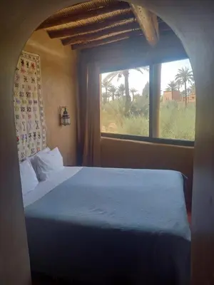 a bedroom with a large bed with a window at Les Jardins de Skoura in Skoura