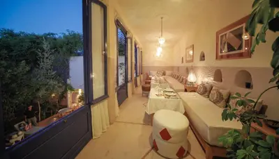 a living room with a long line of couches at Maison d'hôtes Dar Farhana in Ouarzazate