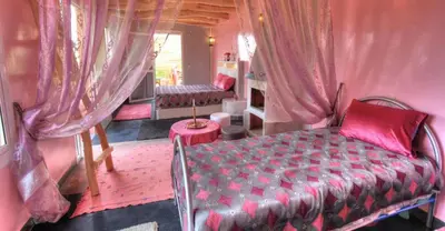 a bedroom with a bed in a room with curtains at Jardin de la source in Aït Yous