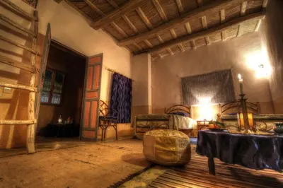 a living room with a bed and a table and chairs at Jardin de la source in Aït Yous