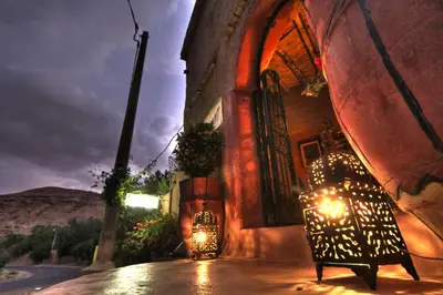 a building with a bench in front of it at night at Jardin de la source in Aït Yous